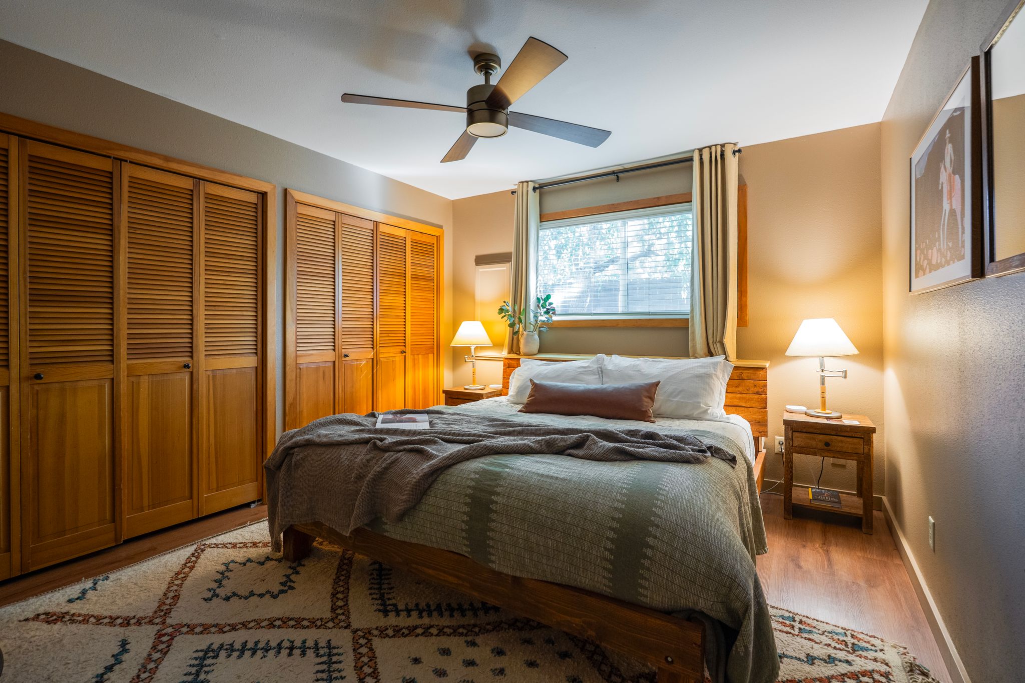 Bedroom with queen bed, green bedspread and wood closets