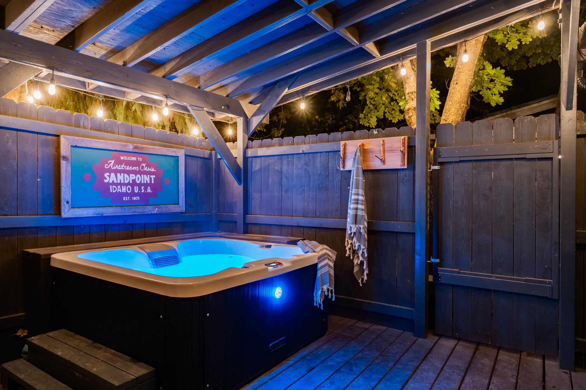 Private hot tub glowing at night under string lights
