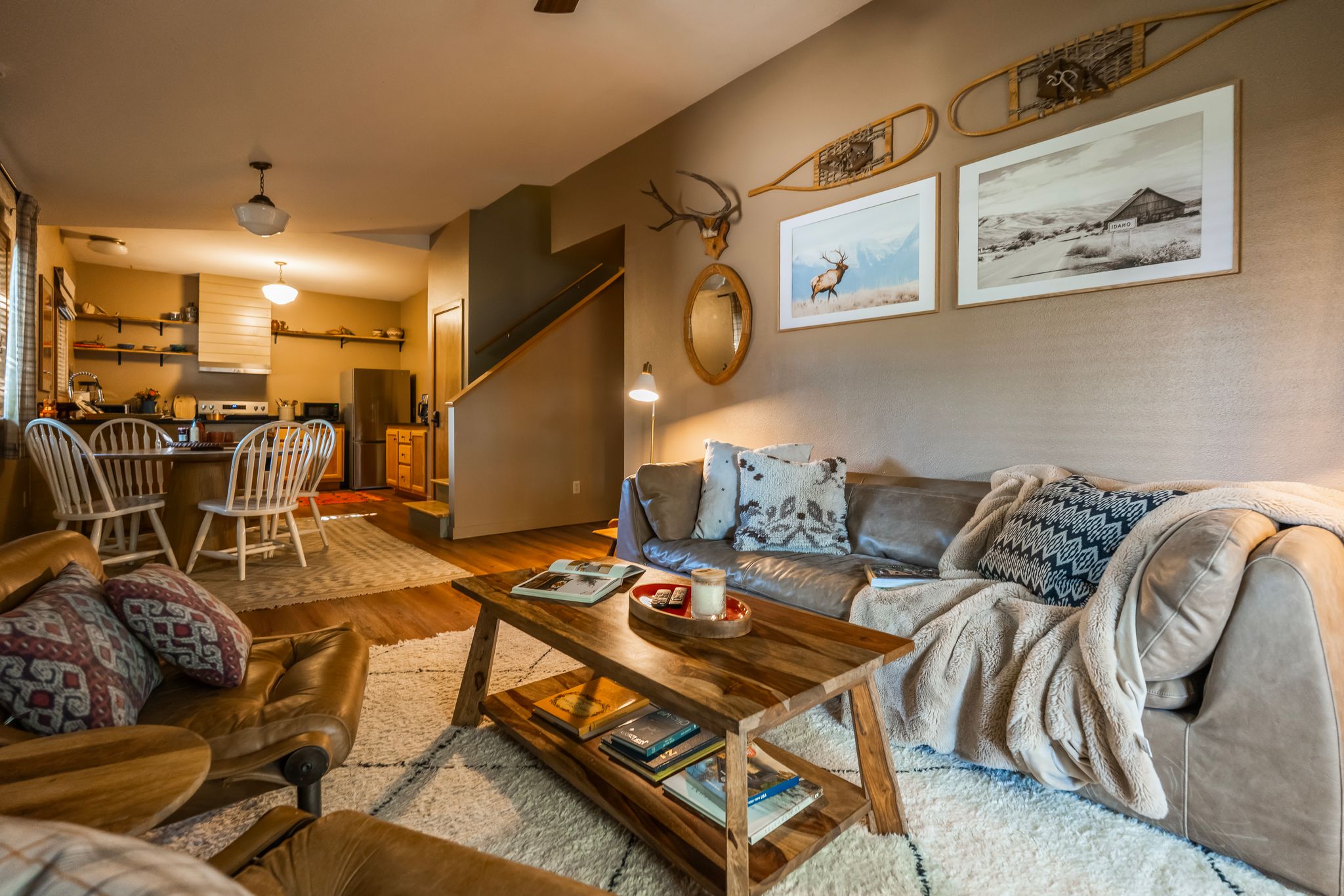Open living room with leather sofa looking toward the kitchen and dining area