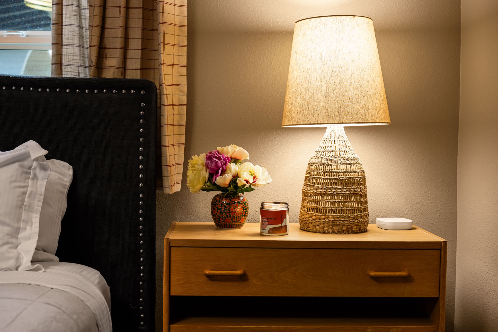 Bedroom nightstand with fresh flowers and warm lamp