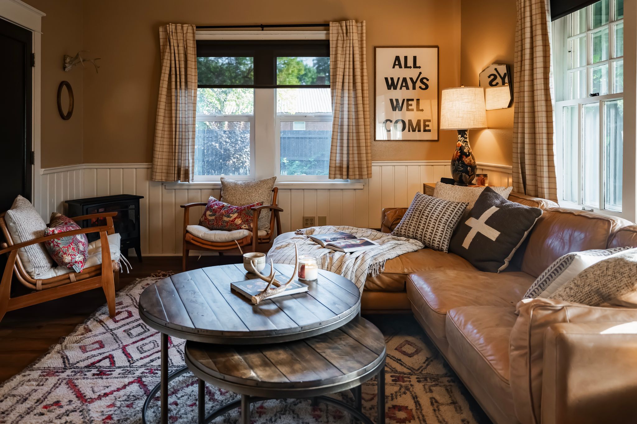 Cozy living room with All Ways Welcome sign and leather sofa