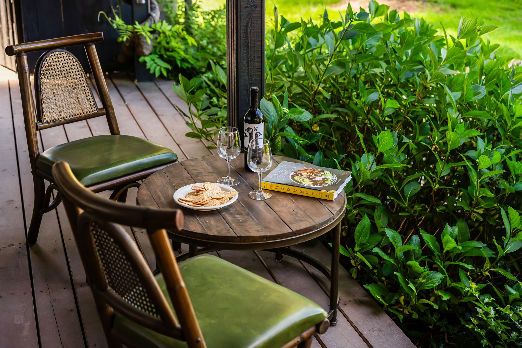 Intimate outdoor dining table with wine and greenery