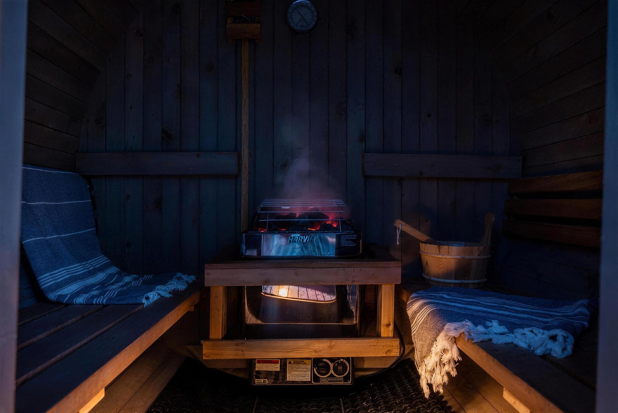 Interior of the cedar barrel sauna with Harvia heater and bucket