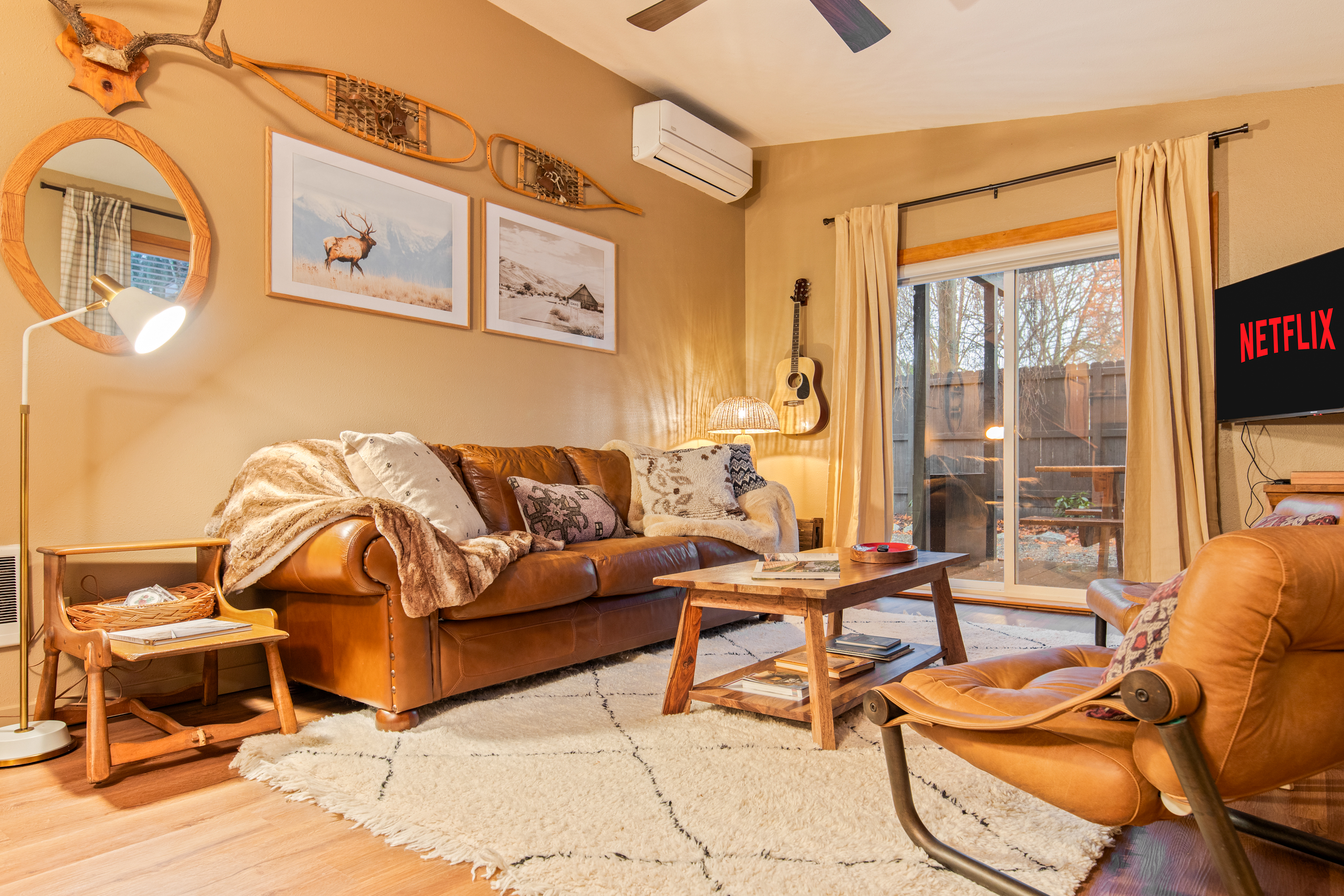 Cozy living room with leather sofa, blankets, and ambient lighting